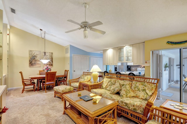 carpeted living room with a textured ceiling, ceiling fan, and lofted ceiling