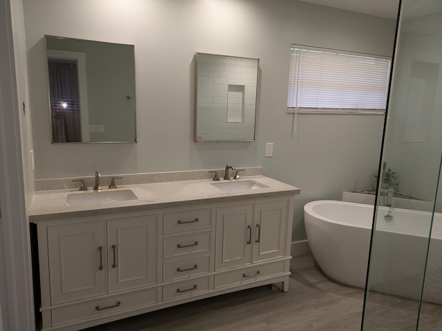 bathroom featuring vanity, a bath, and hardwood / wood-style flooring