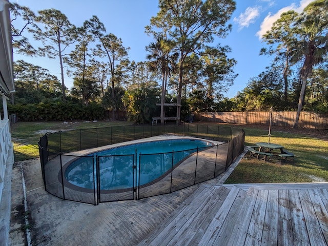 view of pool featuring a deck and a lawn