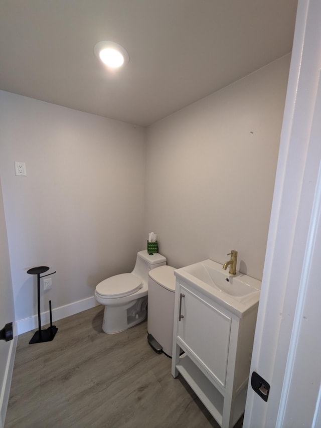 bathroom featuring vanity, wood-type flooring, and toilet