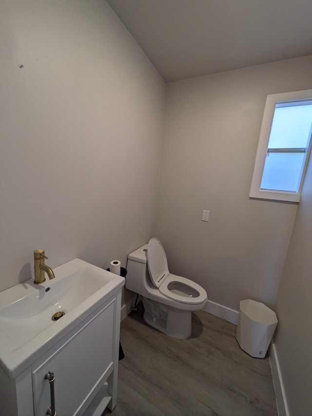 bathroom with hardwood / wood-style floors, vanity, and toilet