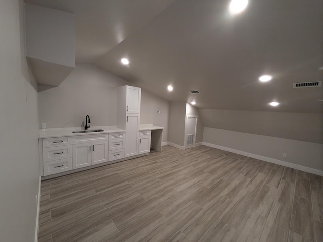 bonus room featuring lofted ceiling, light wood-type flooring, and sink