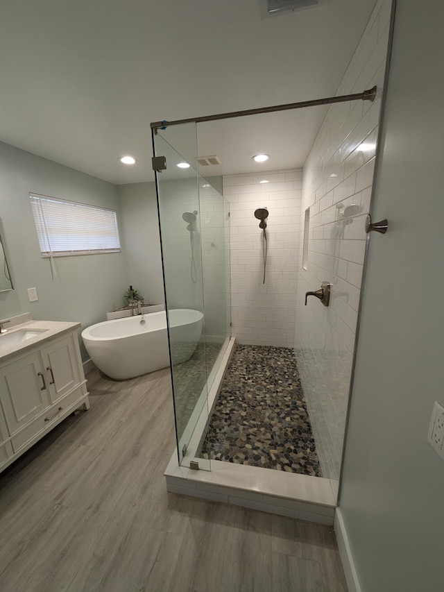 bathroom with vanity, hardwood / wood-style flooring, and independent shower and bath