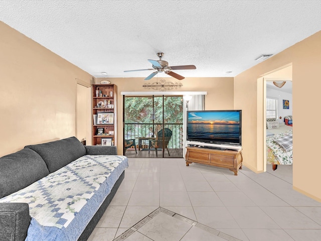 tiled living room with ceiling fan and a textured ceiling