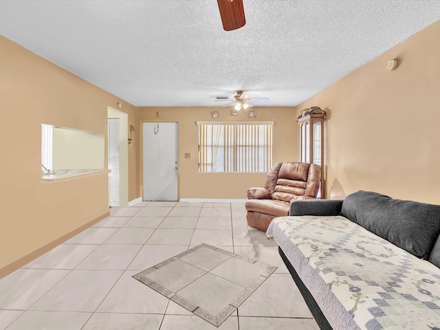 living room with ceiling fan and a textured ceiling