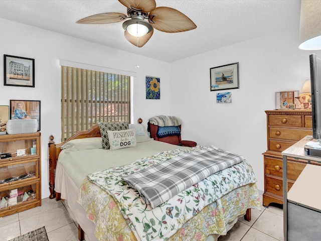 tiled bedroom featuring ceiling fan and a textured ceiling