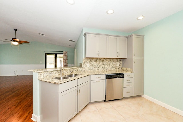 kitchen with lofted ceiling, sink, stainless steel dishwasher, light wood-type flooring, and kitchen peninsula