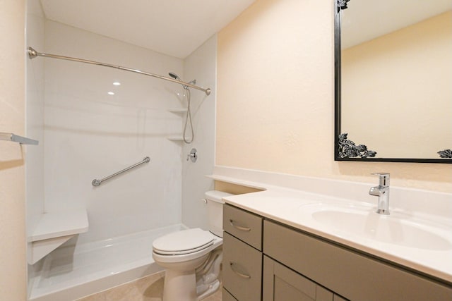 bathroom featuring tile patterned flooring, vanity, toilet, and a shower