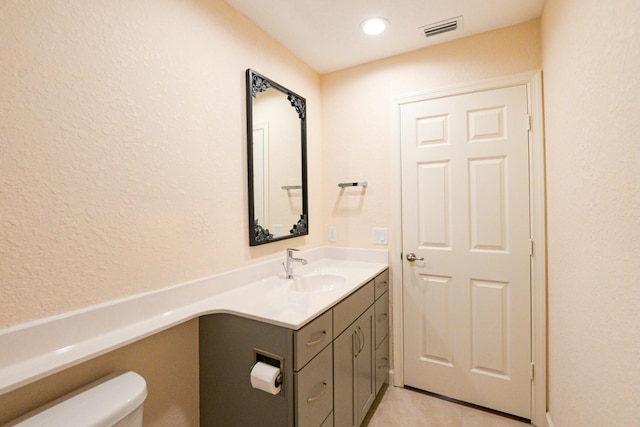 bathroom with tile patterned flooring, vanity, and toilet