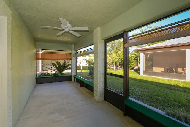 unfurnished sunroom with ceiling fan