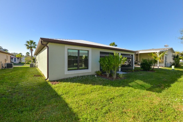 rear view of house with a lawn and central air condition unit