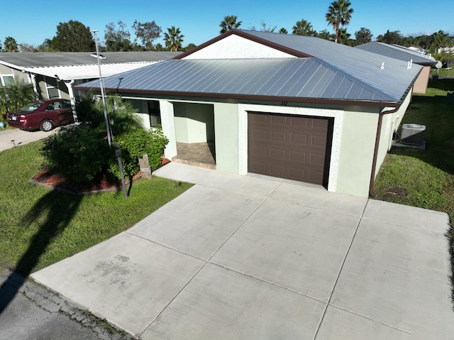 view of front of house with a front yard, a garage, and cooling unit