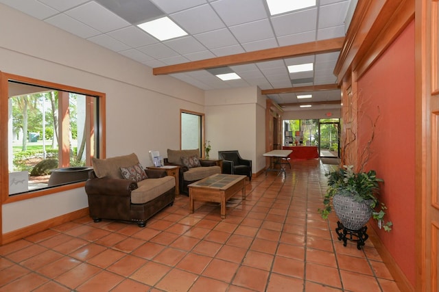 living room featuring tile patterned floors and a drop ceiling