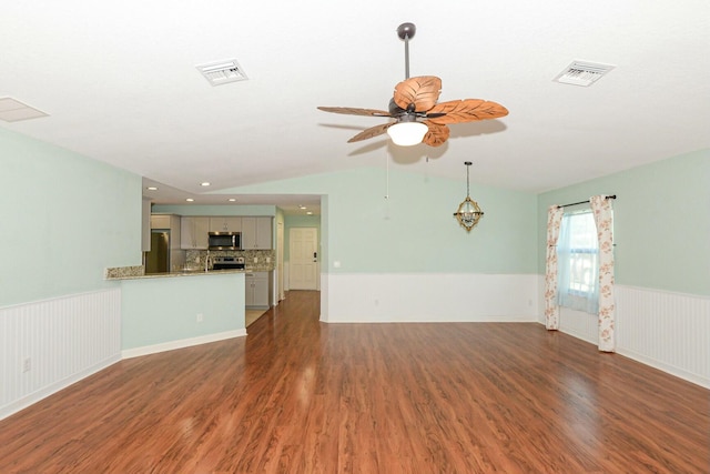 unfurnished living room with vaulted ceiling, ceiling fan, and dark wood-type flooring