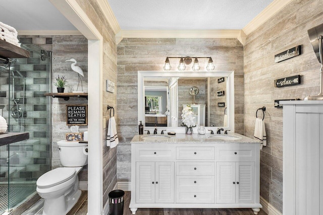 bathroom with vanity, wooden walls, toilet, a textured ceiling, and a shower with shower door