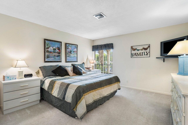 bedroom with light carpet and a textured ceiling