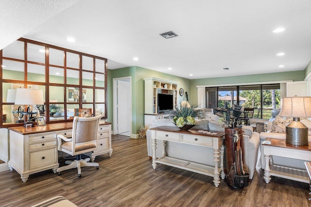 home office featuring dark hardwood / wood-style floors and built in desk