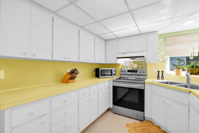 kitchen featuring appliances with stainless steel finishes, white cabinetry, a drop ceiling, and sink