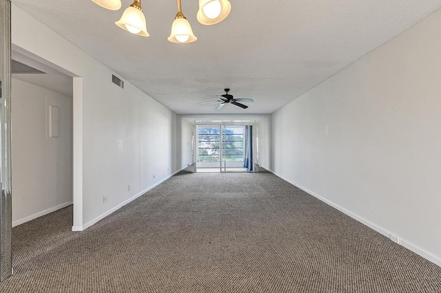 unfurnished room featuring a textured ceiling, ceiling fan with notable chandelier, and dark colored carpet