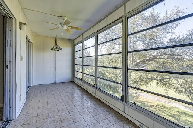 unfurnished sunroom with ceiling fan