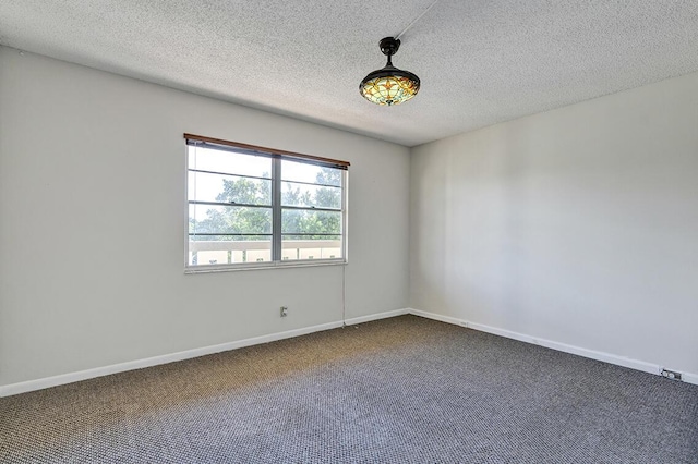 carpeted empty room featuring a textured ceiling