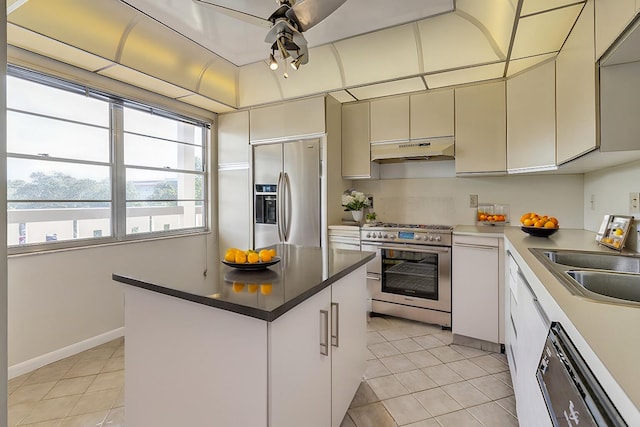 kitchen featuring a center island, sink, stainless steel appliances, light tile patterned floors, and white cabinets