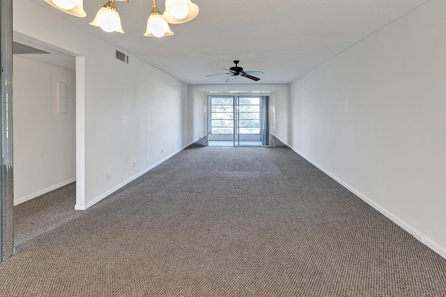 carpeted empty room featuring ceiling fan with notable chandelier