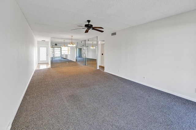 unfurnished living room with ceiling fan and a textured ceiling