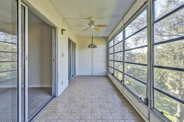 unfurnished sunroom with ceiling fan