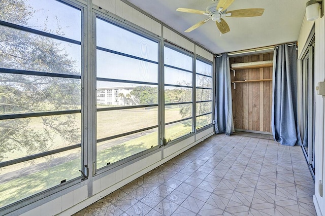 unfurnished sunroom with plenty of natural light and ceiling fan