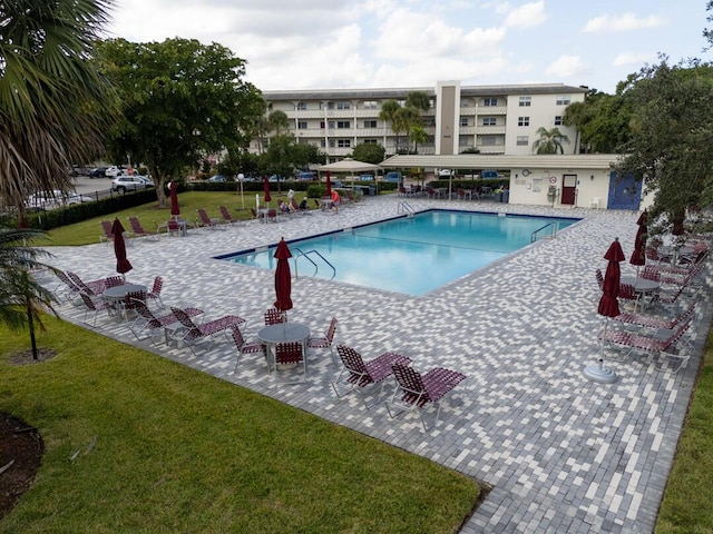 view of swimming pool with a lawn and a patio area