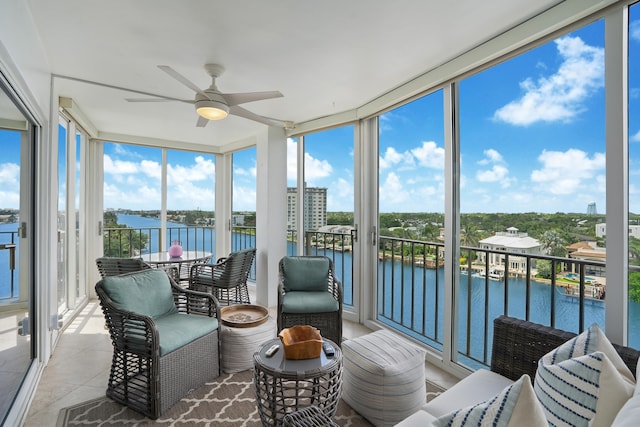 sunroom / solarium with a wealth of natural light, a water view, and ceiling fan