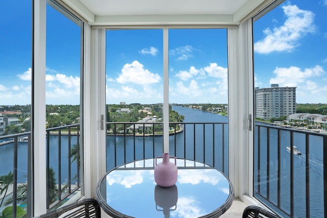 sunroom featuring a water view