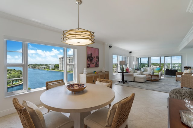 dining area featuring a water view, ornamental molding, and light tile patterned flooring