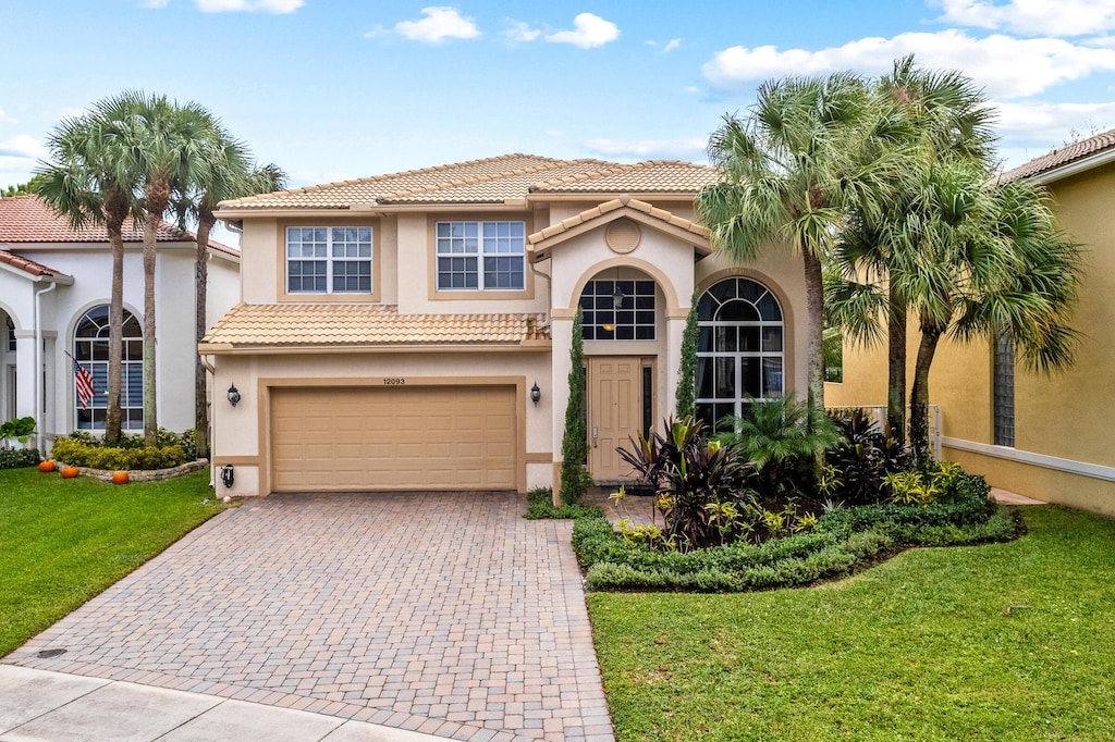 mediterranean / spanish-style home with a front yard and a garage