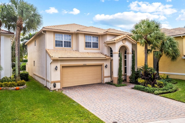 mediterranean / spanish-style house featuring a garage and a front lawn