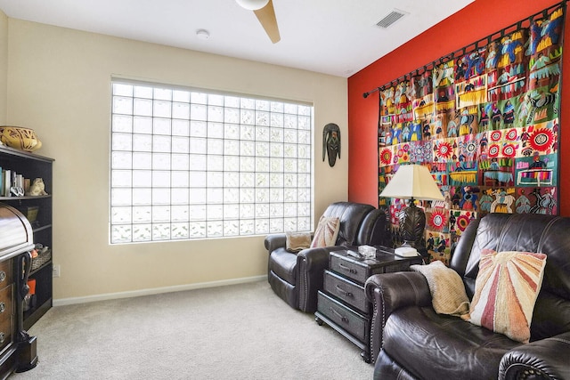 living area with carpet and ceiling fan