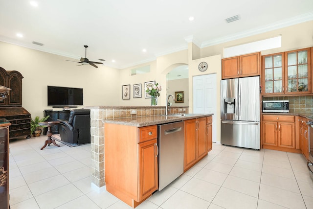 kitchen with visible vents, decorative backsplash, appliances with stainless steel finishes, light stone countertops, and a sink