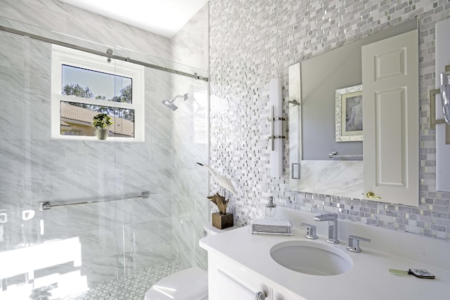 full bath featuring toilet, vanity, tile walls, backsplash, and a marble finish shower