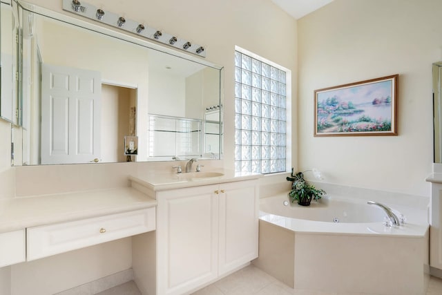 bathroom with a tub with jets, tile patterned flooring, and vanity