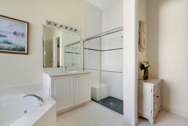 bathroom with a stall shower, a jetted tub, vanity, and tile patterned floors