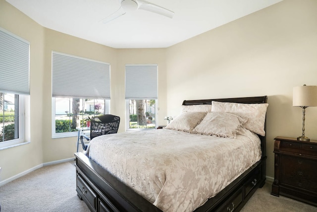 bedroom featuring light carpet, ceiling fan, and baseboards