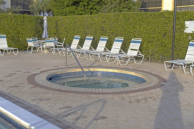 view of swimming pool with a patio and a hot tub