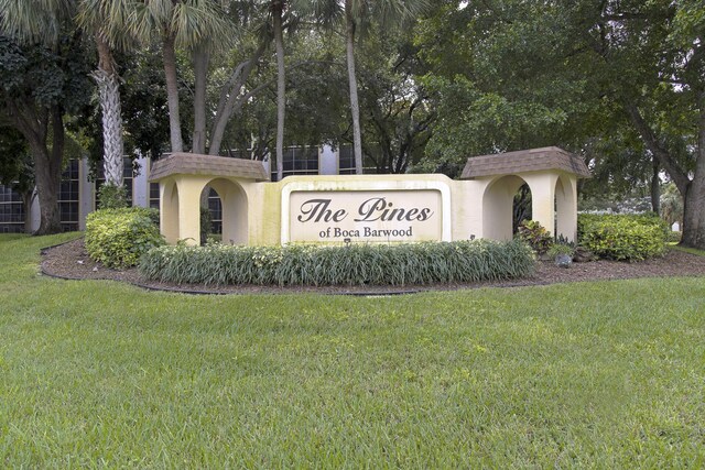 community / neighborhood sign featuring a lawn