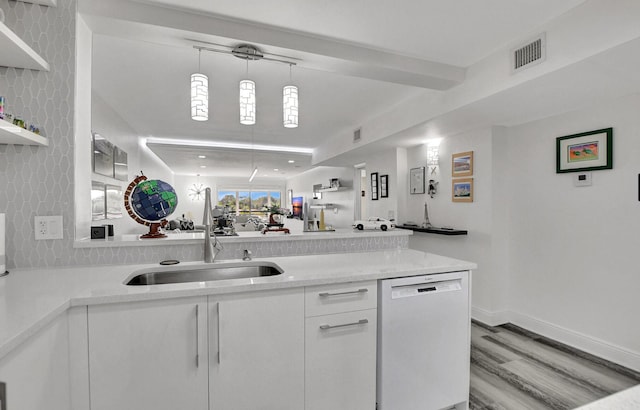 kitchen featuring white dishwasher, sink, decorative light fixtures, white cabinets, and light hardwood / wood-style floors