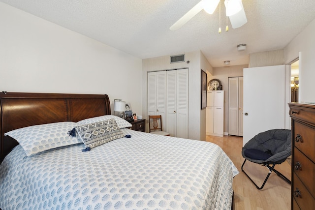 bedroom featuring ceiling fan, light wood-type flooring, and a textured ceiling