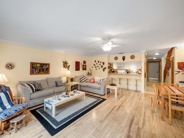 living room featuring ceiling fan, light hardwood / wood-style floors, and crown molding