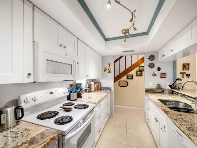 kitchen with sink, light stone counters, white appliances, a tray ceiling, and white cabinets