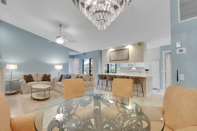 tiled dining area with ceiling fan with notable chandelier, sink, and vaulted ceiling