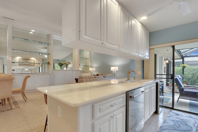 kitchen featuring light tile patterned flooring, ceiling fan, white cabinets, and stainless steel dishwasher